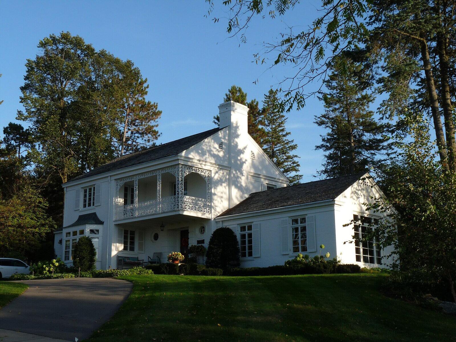 A white Colonial Revival home with dormers and a balcony in Wausau